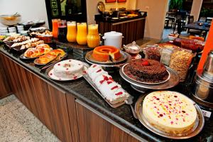 a buffet with different types of cakes and other desserts at Hotel Metropolitan in Campo Grande