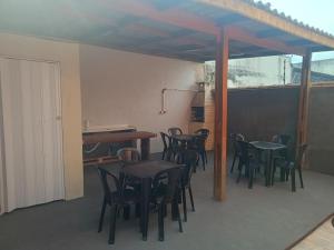a group of tables and chairs on a patio at Aconchego em Bertioga in Bertioga