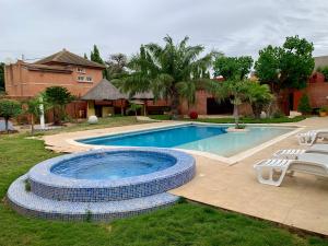 a swimming pool in a yard next to a house at L'Anse des Amarantes in Saly Portudal