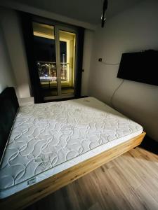 28th Floor Sky City View Apartment في إسكوبية: سرير كبير في غرفة مع نافذة