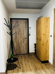 28th Floor Sky City View Apartment في إسكوبية: غرفة فيها باب خشبي ومصنع +27 صورة