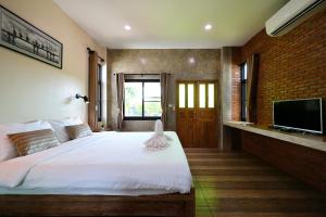 a bedroom with a large bed and a tv at Chiang Mai Garden Bungalows in Chiang Mai +58 photos