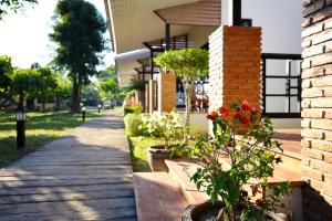 a sidewalk with potted plants on the side of a building at Chiang Mai Garden Bungalows in Chiang Mai