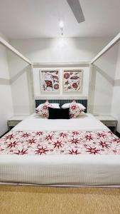 a bedroom with a large bed with a red floral bedspread at Vintage 83 Tangalle in Tangalle