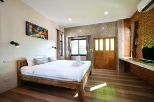 a bedroom with a bed and a tv in it at Chiang Mai Garden Bungalows in Chiang Mai