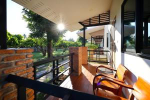 a balcony of a house with two wooden benches at Chiang Mai Garden Bungalows in Chiang Mai +61 photos