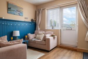 モイルブレにあるDryw at Deanfield House Adult only Sea View Apartment in Moelfre by Lazy Days Angleseyのリビングルーム(椅子2脚、窓付)