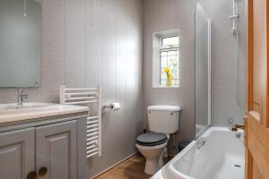 モイルブレにあるDryw at Deanfield House Adult only Sea View Apartment in Moelfre by Lazy Days Angleseyのトイレ、洗面台、浴槽を備えたバスルーム