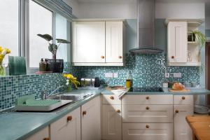 モイルブレにあるDryw at Deanfield House Adult only Sea View Apartment in Moelfre by Lazy Days Angleseyの白いキャビネットとシンクのあるキッチン