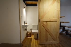 a bathroom with a toilet and a wooden door at Agapi in Kissamos