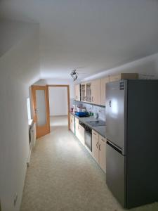 eine leere Küche mit Kühlschrank und Spüle in der Unterkunft Flonta Ferienwohnung in Mittweida + 7 Fotos