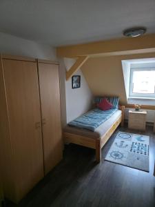 ein kleines Schlafzimmer mit einem Bett und einem Fenster in der Unterkunft Flonta Ferienwohnung in Mittweida