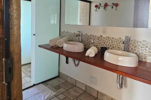 a bathroom with two sinks and a mirror at OPN Guest House Ilhabela in Ilhabela