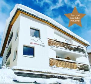 瓜尔达瓜尔达酒店的一栋被雪覆盖的建筑物,上面有个箭头指示公交车,挡风玻璃是双面的。