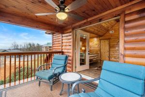 ピジョン・フォージにあるNEW Pine Peaks Mins to Parkway w Amazing Viewsのバルコニーに椅子2脚とテーブルが置かれた小屋