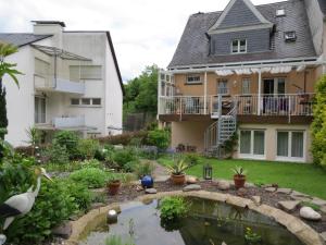 a garden with a pond in front of a house at Ferienwohnung Haus Bleser in Cochem