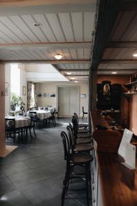 a dining room with tables and chairs and a bar at Pilsbrūzis in Odziena