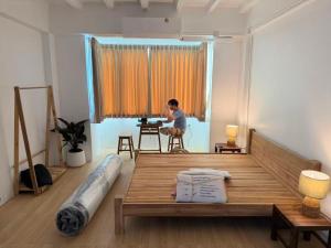 チェンマイにあるCloud Houseの部屋のテーブルに座る男