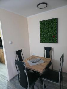 a dining room table with chairs and a painting on the wall at Black House Spa in Gamzigrad +1 photo