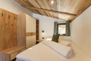 a bedroom with a white bed and a window at Schlicki's Bergchalet in Filzmoos