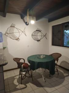 a dining room with a table and some fish on the wall at Lorena'Haus in Bombinhas