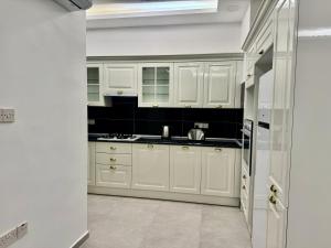 a kitchen with white cabinets and a sink at Soğular Apartments 1 in Aglantzia