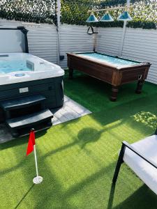 a pool table sitting on the grass with a small flag at The Chroma Cottage in Cock Hill