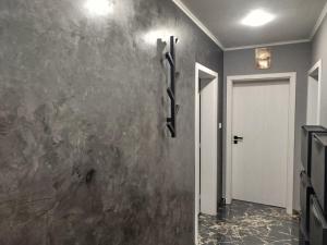 a hallway with a stone wall with a white door at Apartment Diva in Shumen
