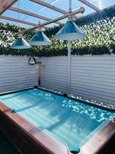a swimming pool with two lights and an umbrella at The Chroma Cottage in Cock Hill