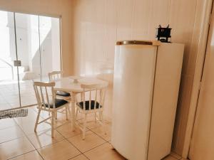 a white refrigerator in a kitchen with a table at Apartamento Solaris in Cunha