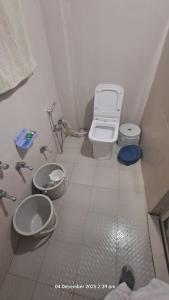 a bathroom with a toilet and two sinks at Sitaram Atithi Grha in Godarpura