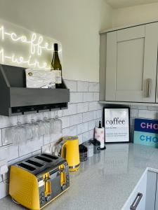 a kitchen with a yellow toaster on a counter at The Chroma Cottage in Cock Hill