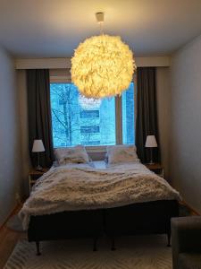 a bedroom with a large bed with a large window at Tievastreet Harmony Apartment in Rovaniemi