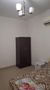 Un dormitorio con una cama y un armario en una habitación. en Fatima Hostel, en Mascate