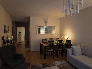 a living room with a table and chairs and a couch at Tievastreet Harmony Apartment in Rovaniemi