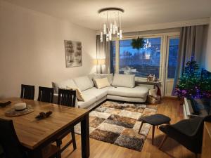 a living room with a couch and a christmas tree at Tievastreet Harmony Apartment in Rovaniemi
