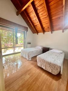 2 letti in una camera con soffitto in legno di Espacio de Calma a La Falda