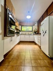 una grande cucina con mobili bianchi e un grande frigorifero di Espacio de Calma a La Falda