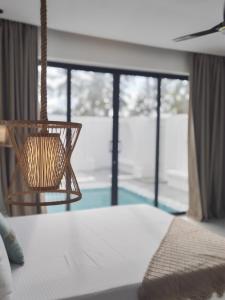 een slaapkamer met een bed met een lamp en een raam bij Amour Beach Villas in Paje