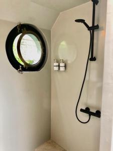 a bathroom with a shower with a round mirror at Houseboat Tante Piet in Amsterdam