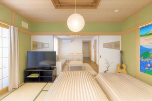 a living room with a tv and a couch at 優中富良野 in Nakafurano