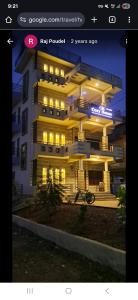 un bâtiment avec des lumières allumées devant lui dans l'établissement Cozy house, à Sauraha