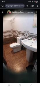 une salle de bains avec toilettes et lavabo dans l'établissement Cozy house, à Sauraha