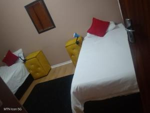 a hotel room with two beds and two chairs at Quigney House on 66 Rhodes in East London