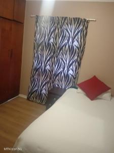 a bed with a patterned headboard in a room at Quigney House on 66 Rhodes in East London