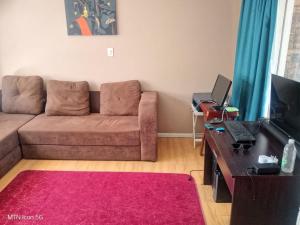 a living room with a couch and a table with a laptop at Quigney House on 66 Rhodes in East London