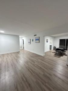 an empty room with a wooden floor and a table at CG Miami House in Miami