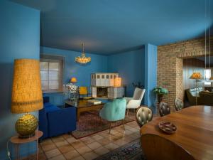 a living room with blue walls and a dining room at Stylish Apartment Zander On The Eider River Bend in Süderstapel