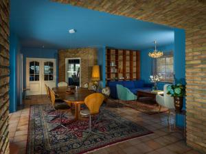 a living room with blue walls and a table and chairs at Stylish Apartment Zander On The Eider River Bend in Süderstapel