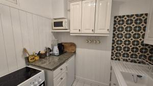 Rose في لو لا فاندو: مطبخ صغير مع دواليب بيضاء وميكرويف